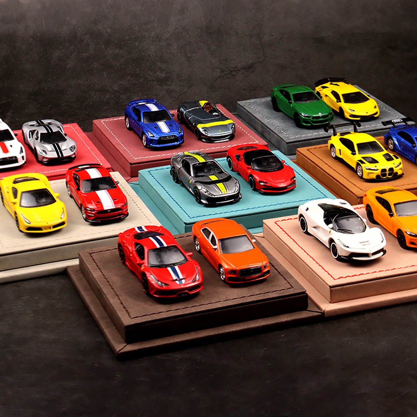 Collection of colorful model cars on display stands against a dark background